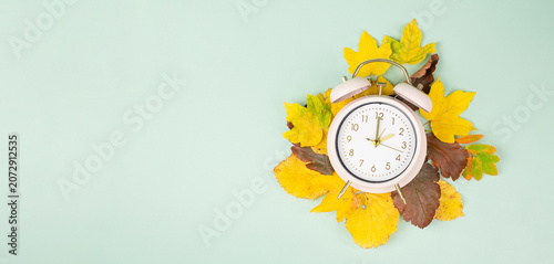Winter time changeover, end of daylight saving time in autumn, alarm clock fall back switch, colorful foliage