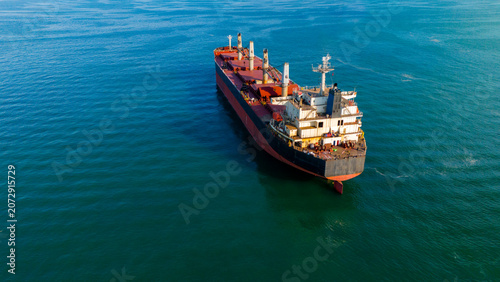 High angle aerial view of a massive dry bulk carrier ship navigating deep waters