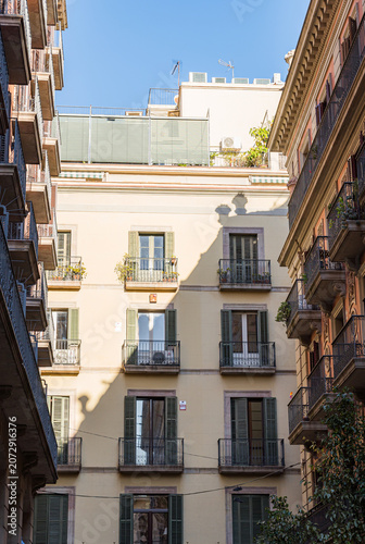 Barcelona building facade with green shutters and balconies
