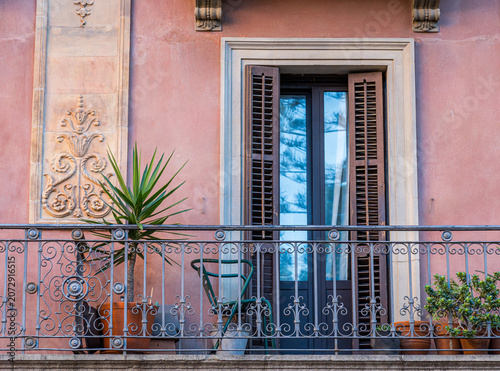 Barcelona building balcony featuring ornate railing and potted plants