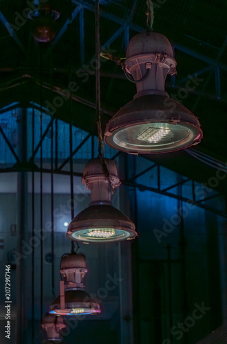 Industrial lamps illuminating a dark market hall interior