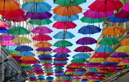 Принти на полотні Colorful umbrellas hanging over a city street against a blue sky, creative urban decoration, summer tourism concept