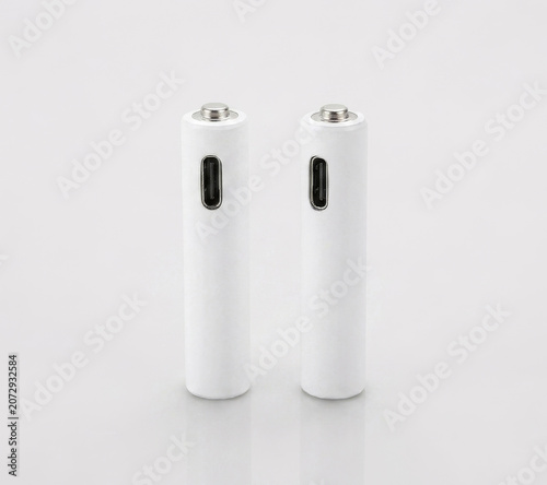 Two white rechargeable AAA lithium batteries with USB-C ports and charging cable on a white background