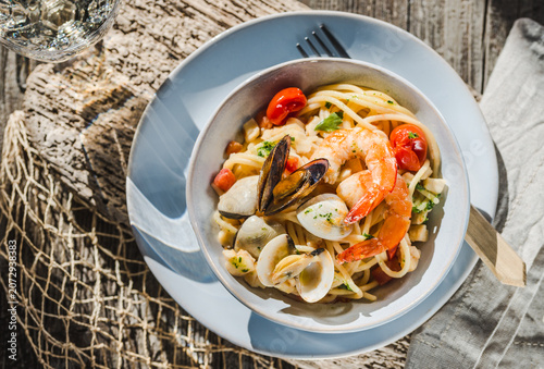 Seafood pasta plate, spaghetti with different claims, shrimps italian food. 	