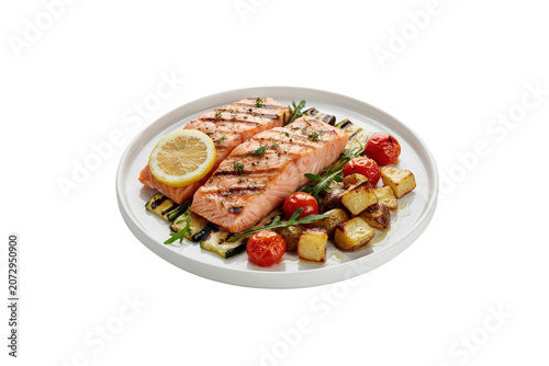 Two pieces of grilled salmon fillet served with roasted potato cubes, cherry tomatoes, and grilled zucchini slices on a white round dinner plate