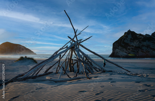 Sticks shaping a tent at the beach. Sunset at the beach of Whanganui inlet westcoast South Island Tasman Sea. New Zealand