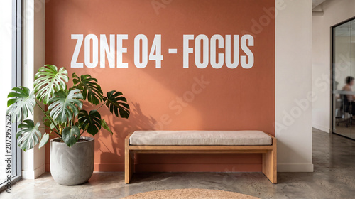 A wooden bench with a beige cushion sits against a terracotta wall with white text reading 