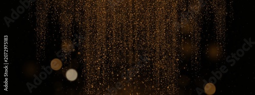 Golden glitter falling against black background. Sparkling dust particles moving downward in darkness. Abstract celebration backdrop for luxury event, New Year gala and festive design.