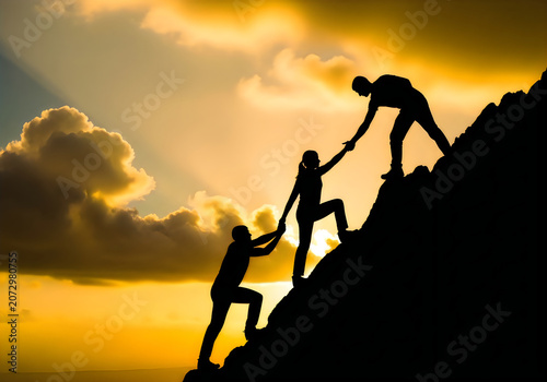 Three people helping each other to climb up a steep rocky mountain peak during a beautiful golden sunset