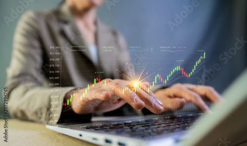 Tableau sur toile Investor typing on laptop with growing stock market graph hologram
