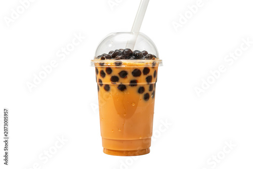 A tall plastic cup filled with creamy orange milk tea and dark chewy tapioca boba pearls, featuring a clear dome lid and a white drinking straw