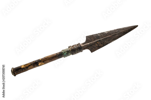 A traditional spear with a pointed metal head and a worn wooden handle, featuring wire binding, isolated on a black background, for inspection