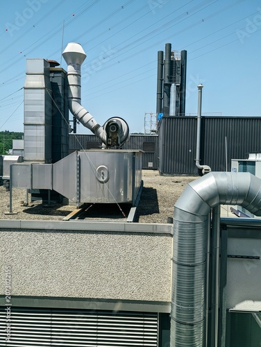 Fotografía Industrial rooftop ventilation ducts fans chimneys under clear blue sky with ove