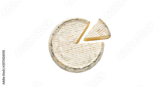 Top view of a creamy round brie cheese wheel with one slice cut out from the textured soft rind surface isolated on a white on transparent background