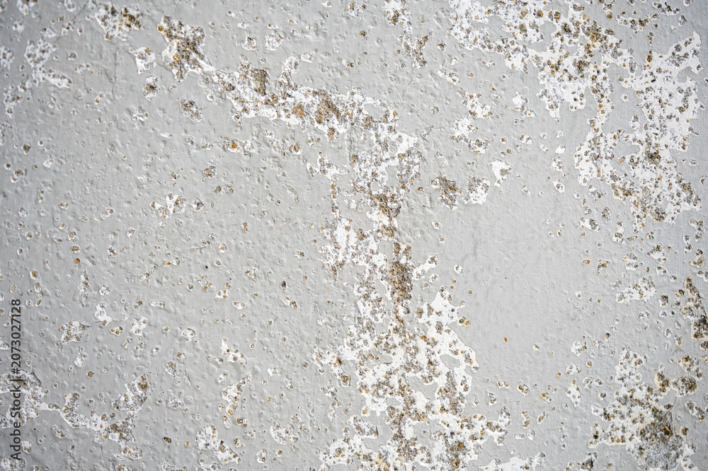 Fototapeta premium Weathered white plaster wall with peeling paint and rough texture, useful as a grunge background or abstract surface for design, renovation, decay, and aged material themes.