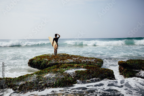Photography Woman surfer with surfboard going to surf at seaside