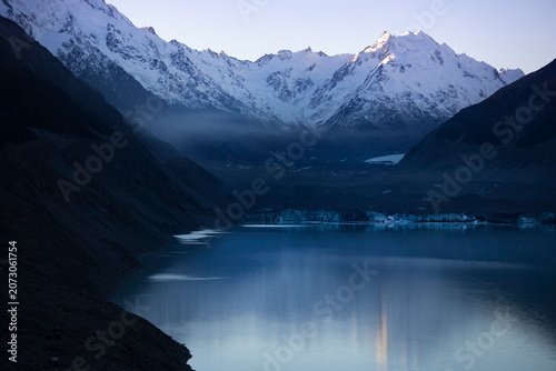 Snow-capped mountain and lake scenery with morning mist