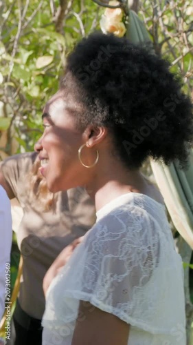 Vertical video: Clapping woman in white-lace getting pat after toast by hammock, flutes, copy space