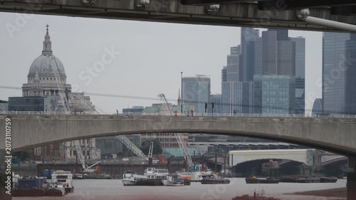 St. Paul's Cathedral and city skyscrapers behind a bridge.