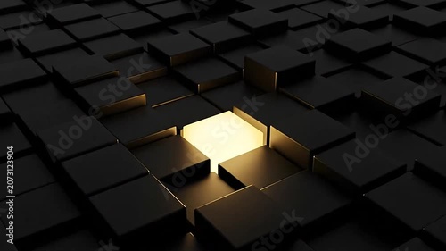 Illuminated block standing out in field of dark cubes.