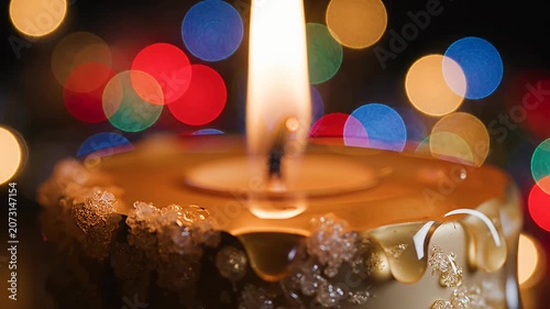 Close up lit candle with soft bokeh lights.
