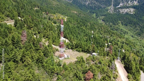 Aerial shot of cellular antenna and substation on remote mountain slope