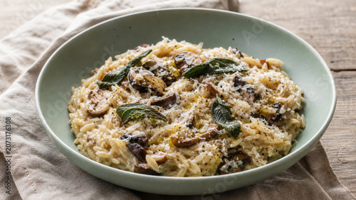 Creamy mushroom risotto with fresh sage and parmesan cheese in a light green generated using ai