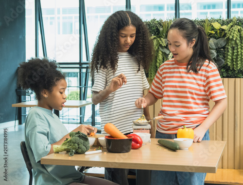 Diverse group young student enjoy healthy cooking class together preparing fresh vegetable learning culinary skill bright modern educational workshop focus nutrition teamwork childhood development.