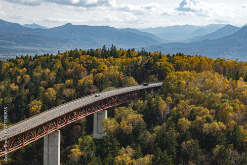 Scenic Matsumi Bridge road trip stretching through autumn golden forest at Mikuni Pass, Hokkaido, Japan