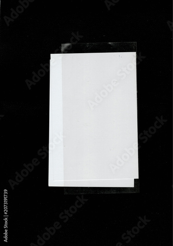 Blank white paper with clear plastic overlay on black background