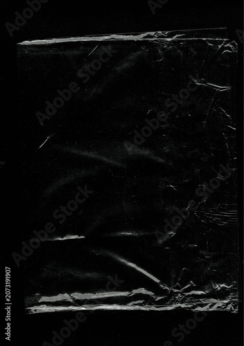 Clear wrinkled plastic wrap texture overlay on black background
