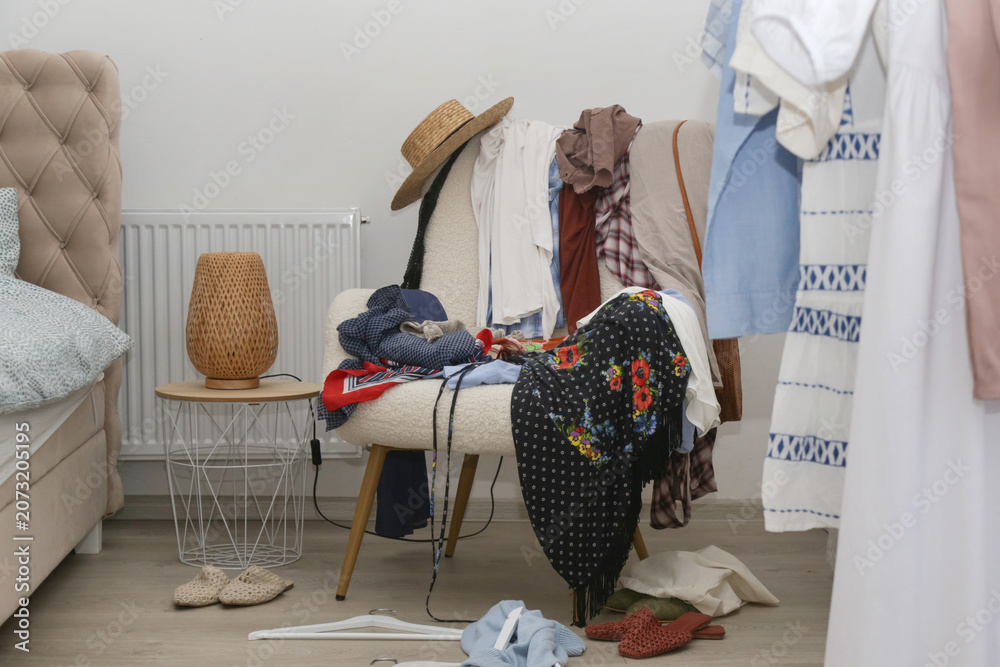Ταπετσαρία Armchair covered with clothes, used as a clothing drop zone, representing everyd