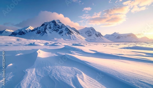 A serene winter landscape featuring snow-covered mountains under a soft, pastel sky.