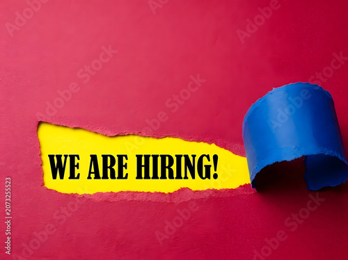We Are Hiring Message Revealed Through Torn Maroon Paper For Recruitment Career Opportunity And Human Resources Concept