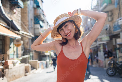 A young woman stands on an old street in Jerusalem and smiles. A Jewish woman. A trip to Israel.