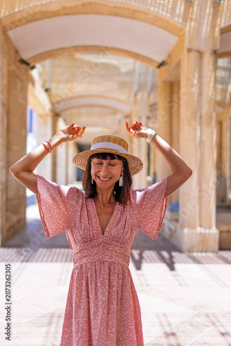 A stylish young woman stands on a street in Jerusalem and smiles. Traveling in Israel.
