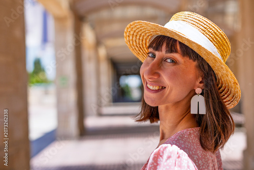 A stylish young woman stands on a street in Jerusalem and smiles. Traveling in Israel.