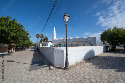 Traditional white mosque with dome architecture and vintage street lamp