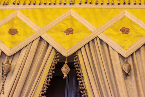 A close-up, detailed view of an ornate, draped canopy
