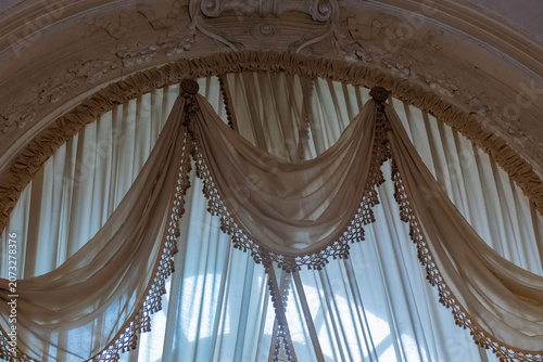 A close-up, detailed view of an ornate, draped canopy, likely part of a bed or a decorative architectural feature, highlighting intricate fabric work and ornate molding
