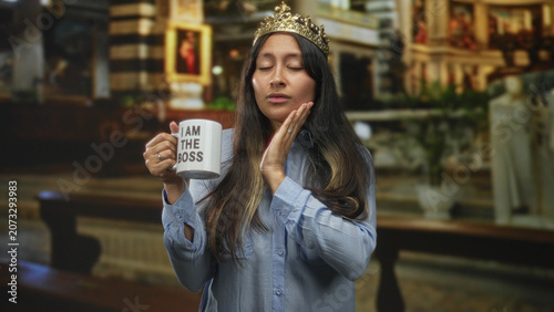 Schilderij op canvas Young latina woman holding mug with text i am the boss and hand on cheek in church building; contemplation irony