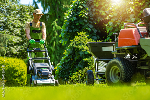 Man mowing the lawn in daytime at a residential garden layout