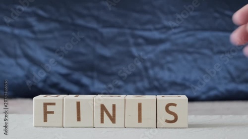 motivational word finish, laying out  by hand from letters on wooden cubes, slow motion
