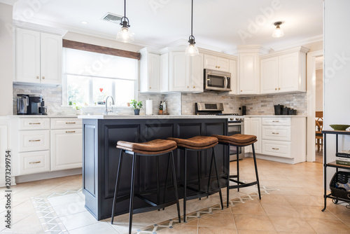 Modern White Kitchen with Black Island and Leather Bar Stools