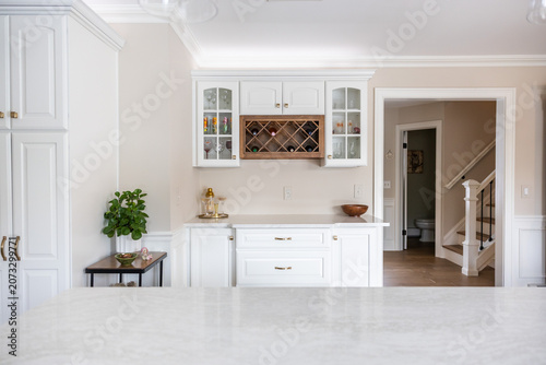 Bright White Kitchen with Built-in Wine Rack and Marble Countertops