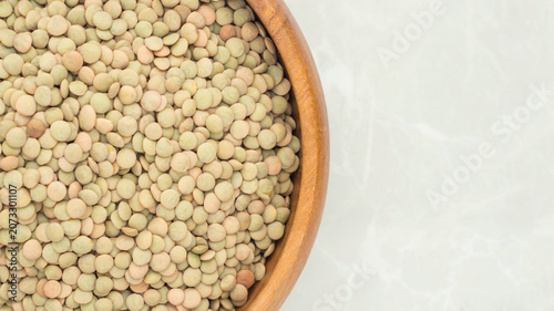 Background image of lentils in a wooden bowl occupying half the screen.	
