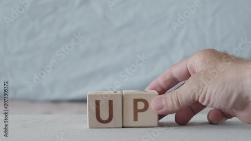 motivational word up, laying out  by hand from letters on wooden cubes, slow motion
