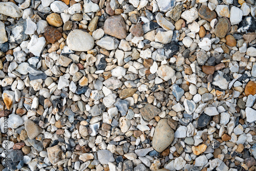 Danish east coast with numerous pebbles on beach in top-view. Maritime background for vacation and tourism.
