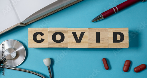 COVID Blocks Displayed with Medical Tools and Pills on Blue Background