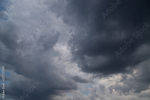 Dark storm clouds roll across a dramatic overcast sky, creating a moody, tense atmosphere with the feel of an imminent thunderstorm and heavy rain approaching.
